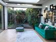 Beautiful Therapy room to rent in house in Wandsworth Common with green sofa, glass walls & garden views, near Tooting Bec