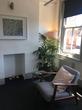 Shoreditch therapy room available to rent in London, Shoreditch High Street with homely feel, plant, seating & window 