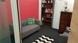 Counselling therapy room to rent near Liverpool Street station, London, with bold red wall, contemporary grey sofa & modern chevron rug