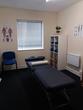 Treatment room to rent in Northfield Birmingham with massage table and musculoskeletal wall charts, suitable for sports massage, osteopaths & physiotherapy